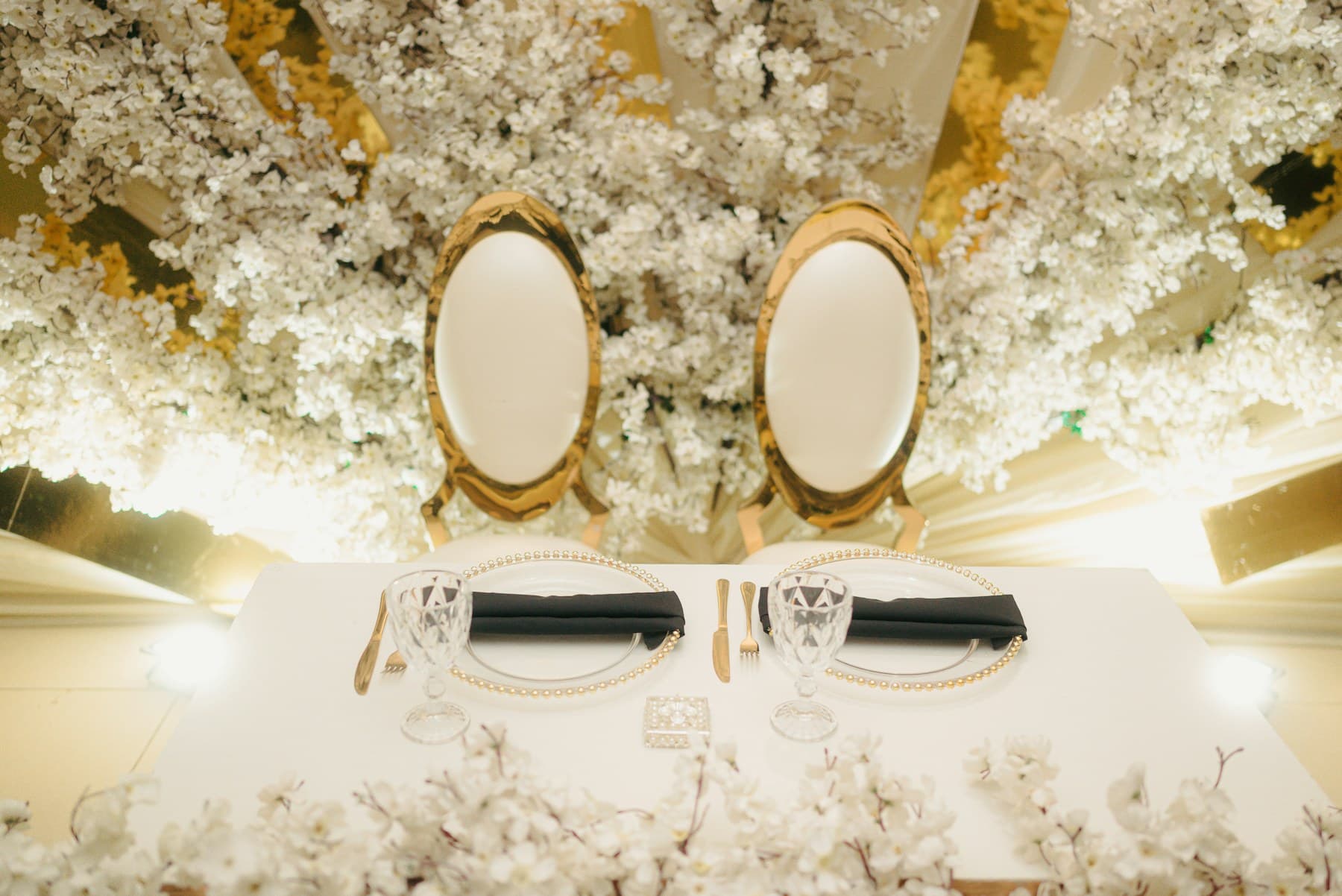 Allestimento evento con tavolo e composizioni floreali luminose dal tono raffinato.