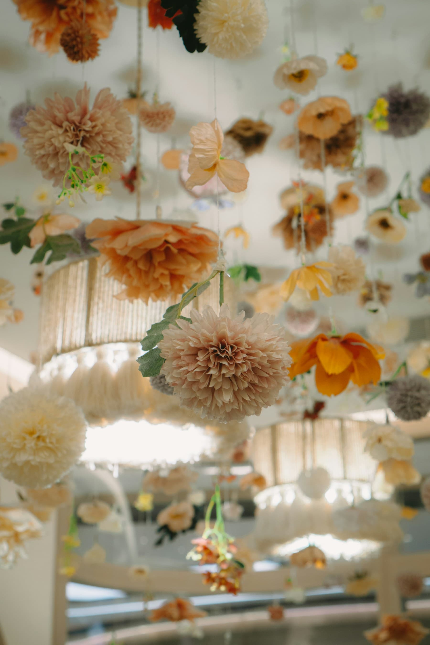 Installazione floreale sospesa con texture morbide e palette neutra.